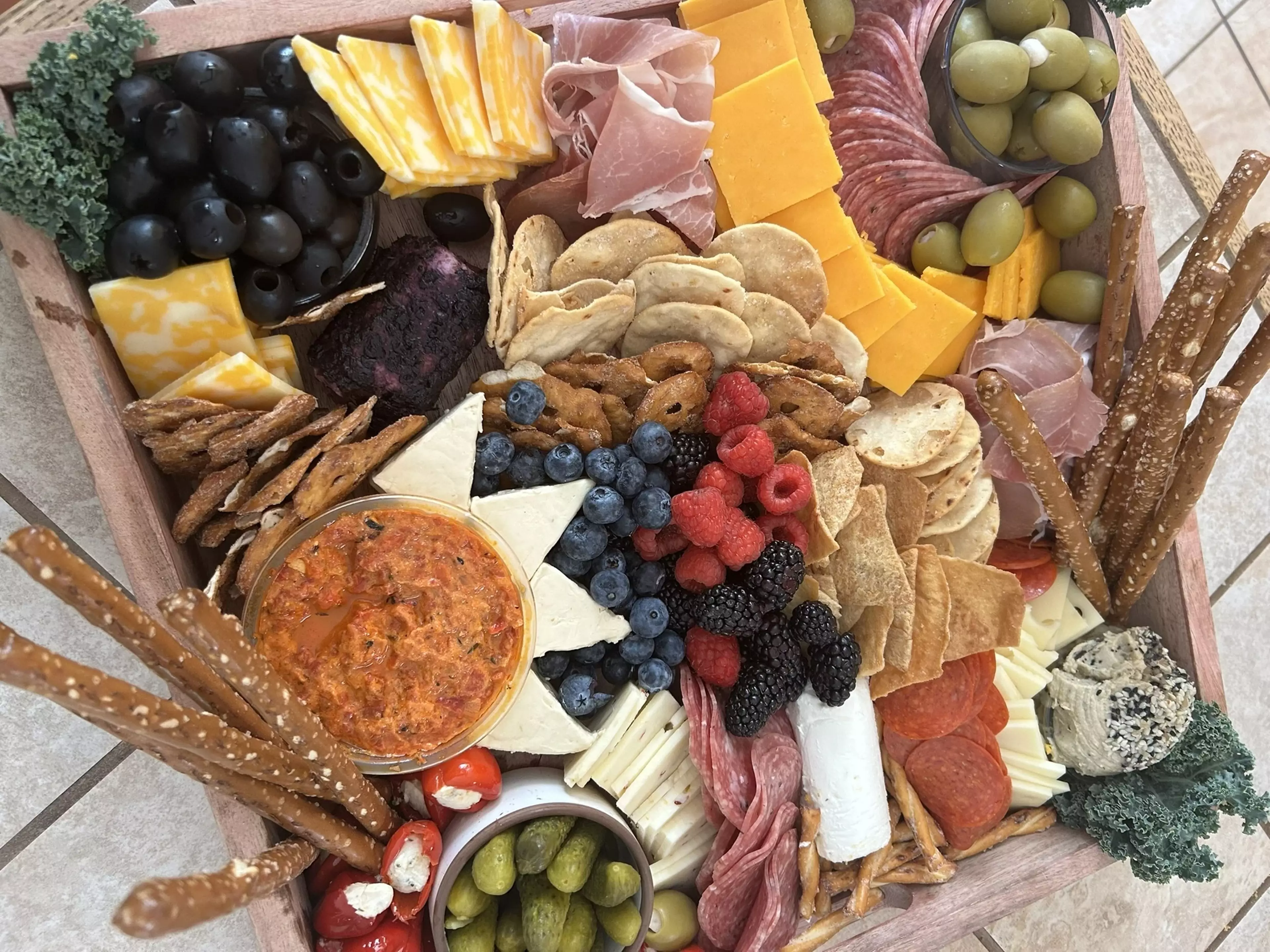 A wide variety of gourmet meats and cheeses organized in a box.