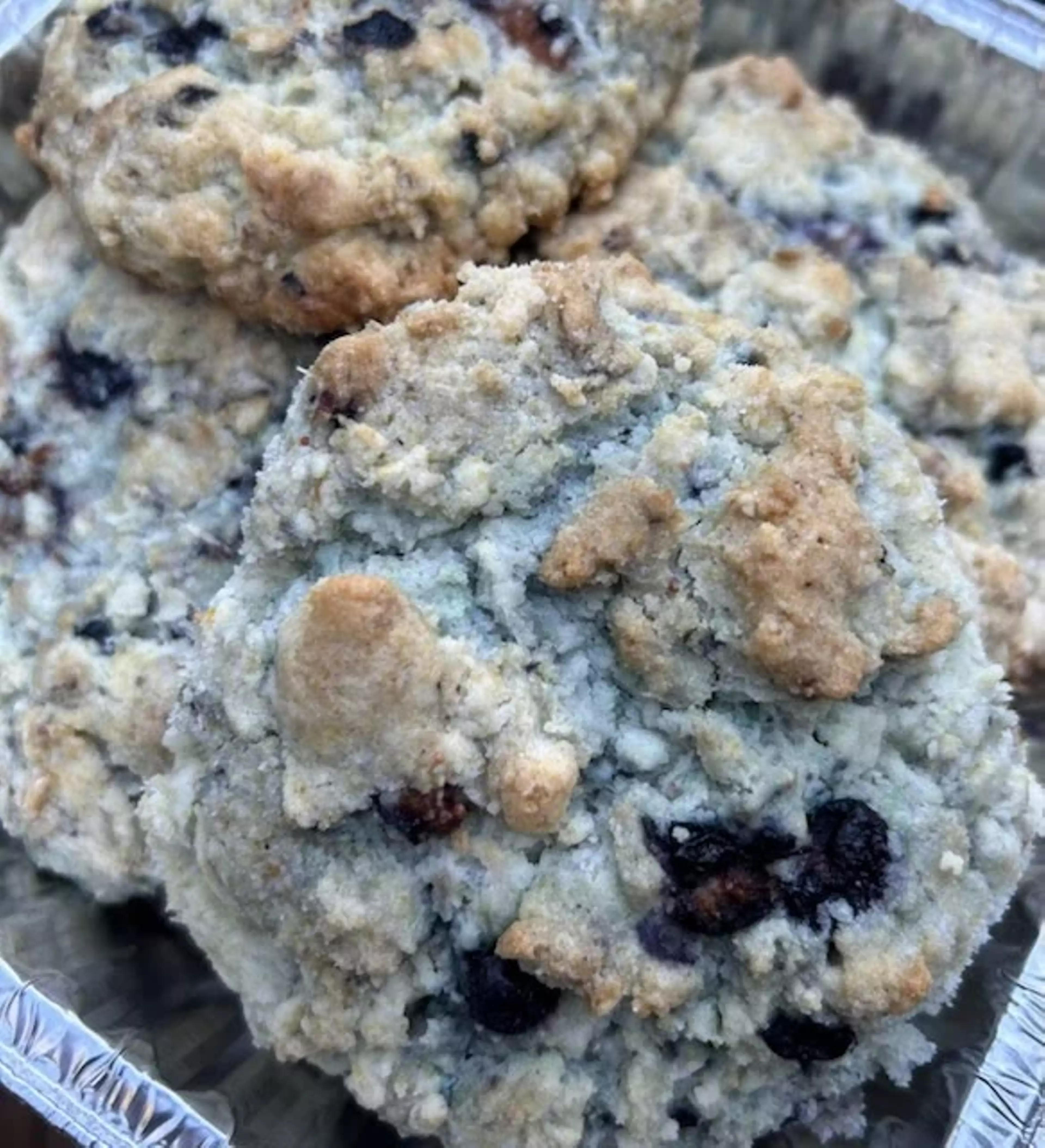 A tin foil tray holding a fresh batch of blueberry scones.