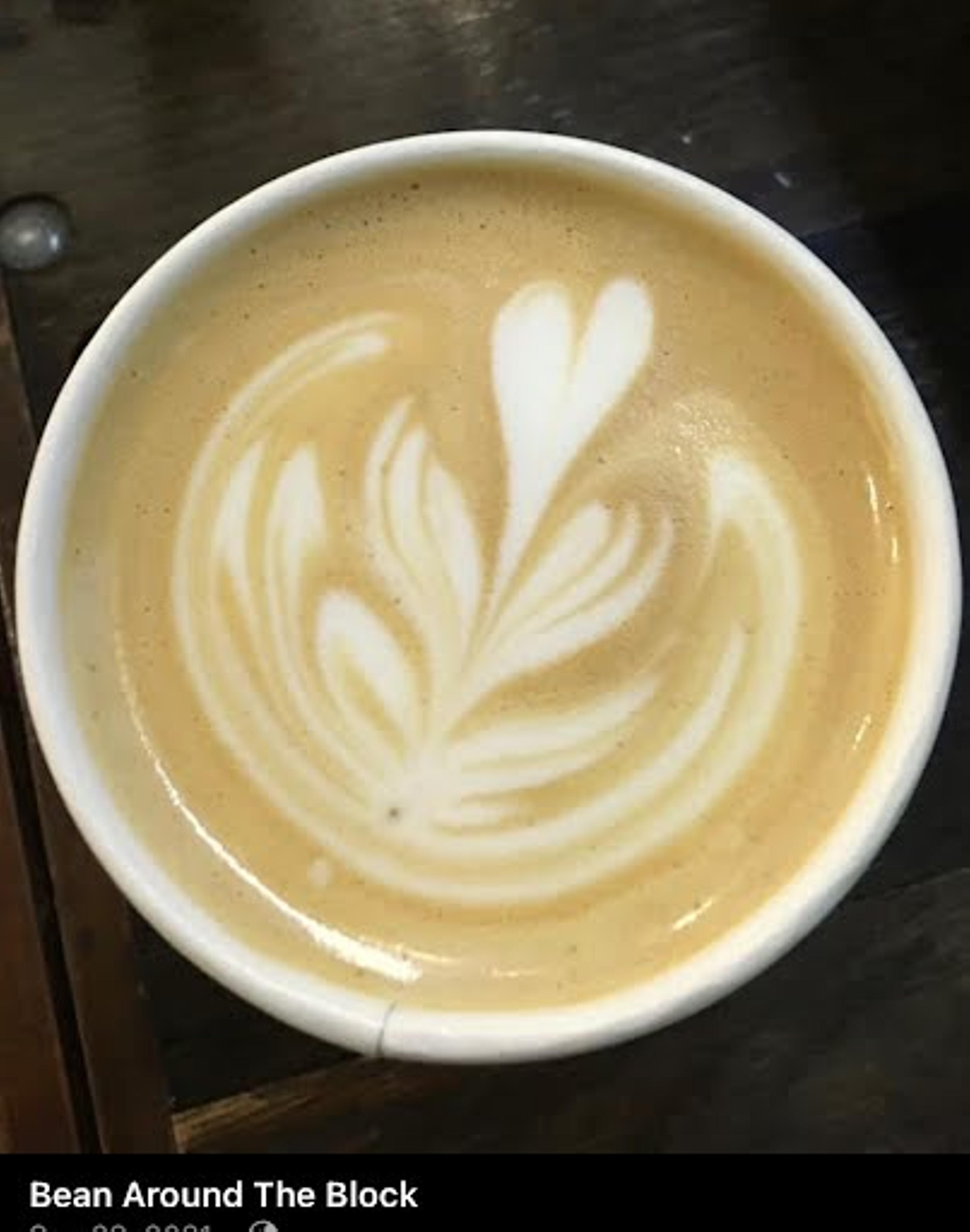 An expertly-crafted latte depicting a leaf in the foam art.