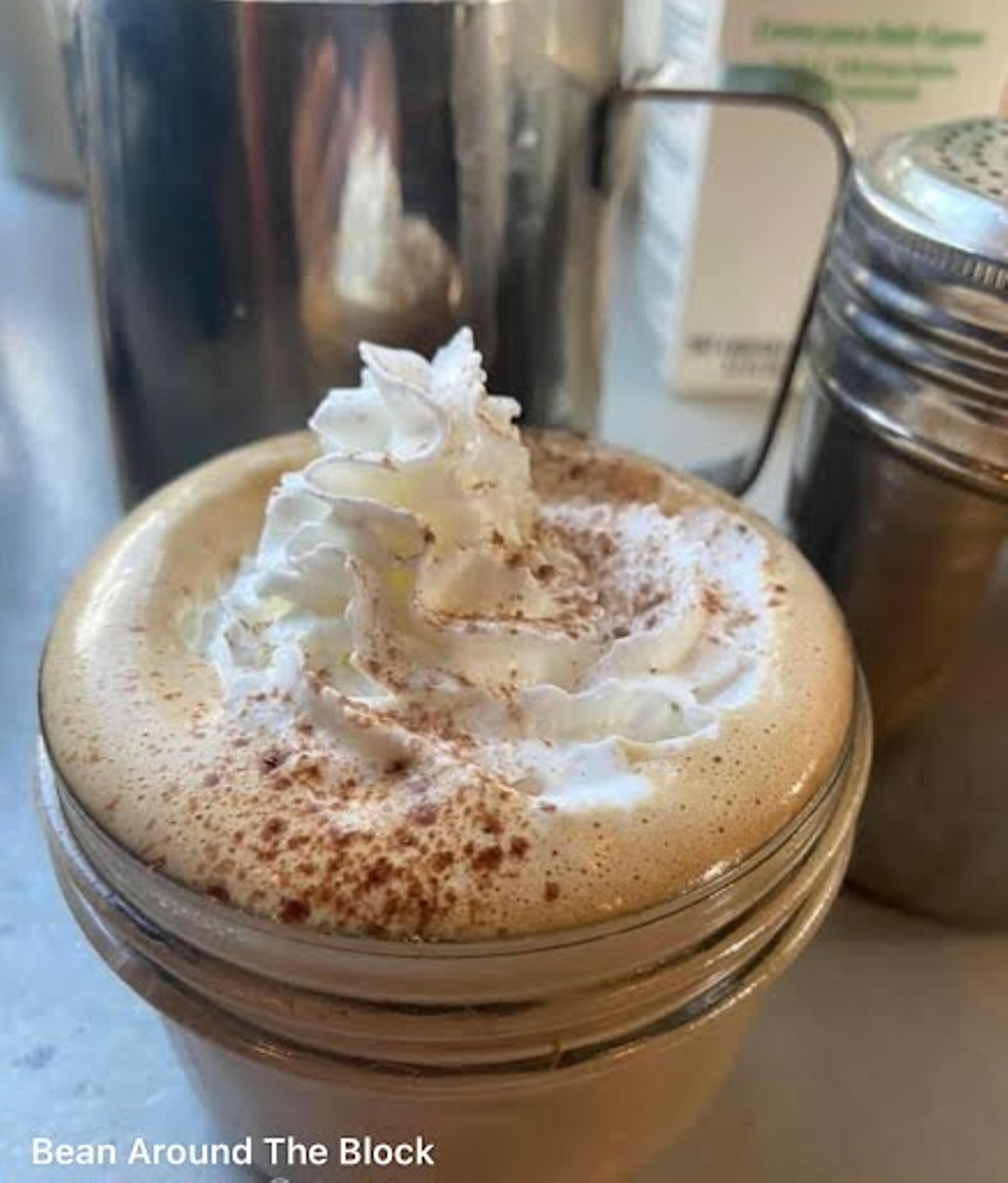 A cold coffee drink topped with whipped cream.